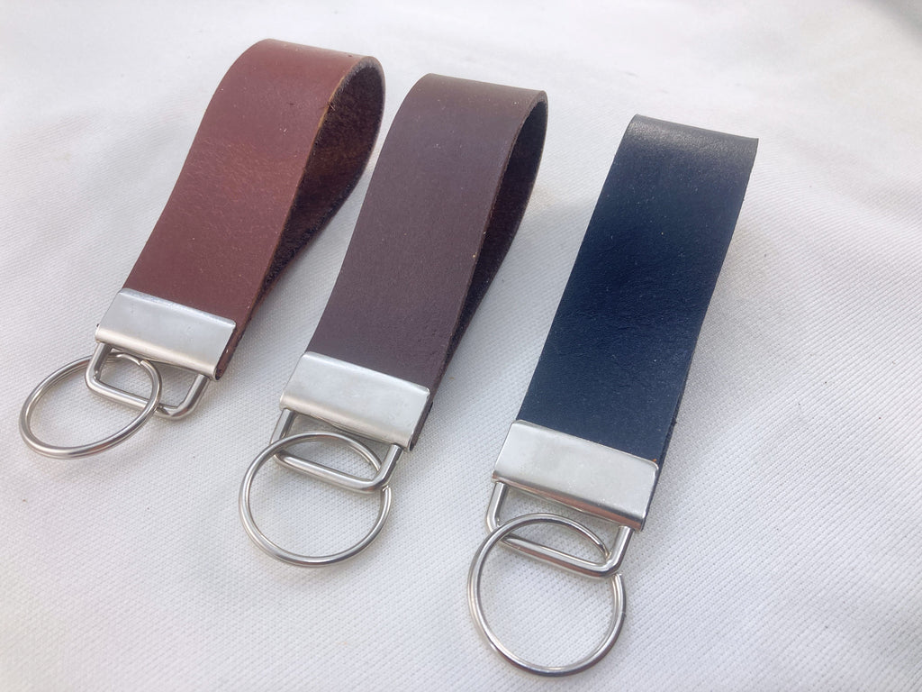 Pair of leather keychains with metal rings, brown, black, and chocolate colors