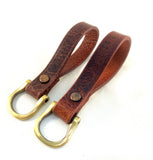 Two brown leather keychains with gold-colored D-rings and buckle closures