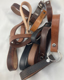 A collection of mixed cowhide leather key fobs in various colors with D-ring attachments, designed to hold keys securely.