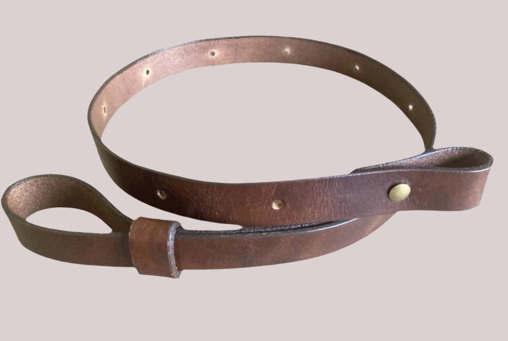 An antique brown leather rifle sling with  adjustment, designed for a carbine or rifle.